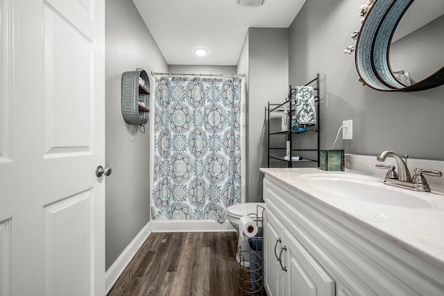 full bathroom featuring wood-type flooring, vanity, shower / bath combo with shower curtain, and toilet