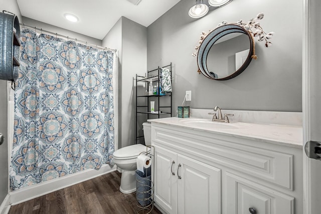 bathroom featuring walk in shower, vanity, toilet, and hardwood / wood-style floors