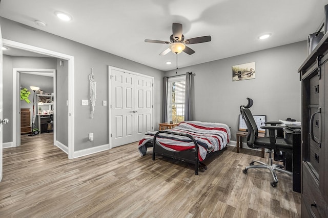 bedroom with hardwood / wood-style flooring, ceiling fan, and a closet