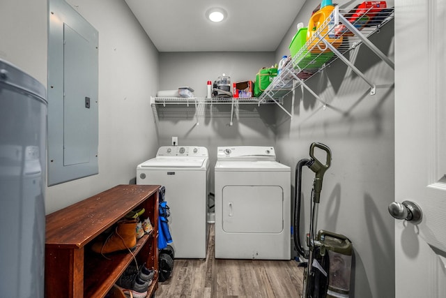 laundry area with electric panel, hardwood / wood-style floors, and washer and dryer