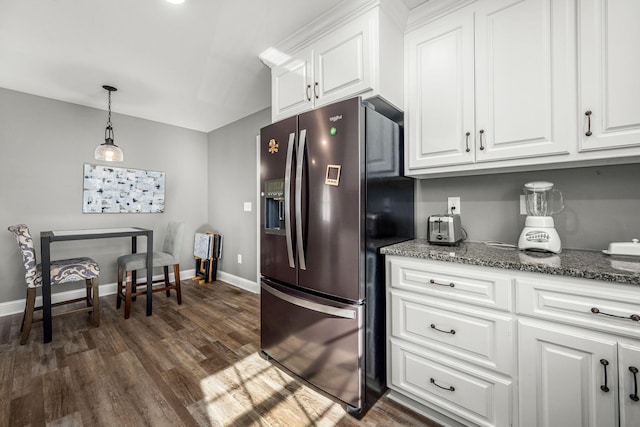 kitchen with white cabinetry, refrigerator with ice dispenser, and dark stone counters