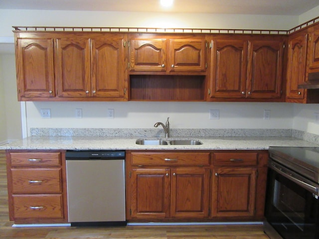 kitchen featuring appliances with stainless steel finishes, dark hardwood / wood-style flooring, light stone countertops, and sink