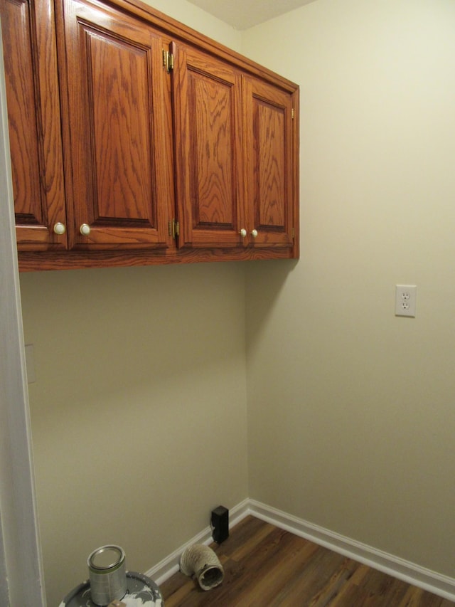 laundry room featuring cabinets and dark hardwood / wood-style flooring