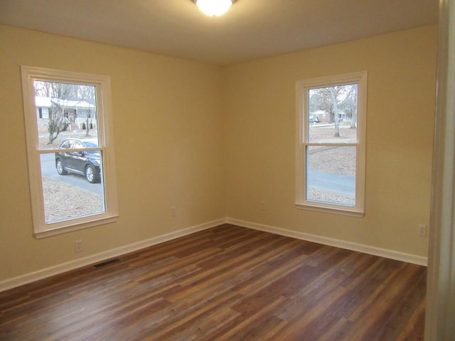 unfurnished room featuring dark hardwood / wood-style flooring and a healthy amount of sunlight