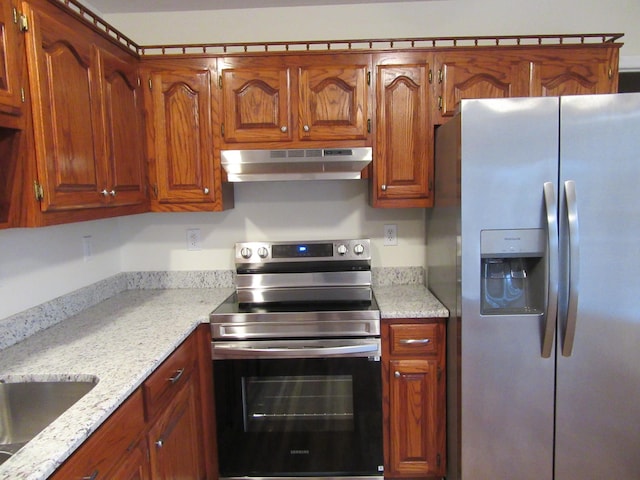 kitchen featuring light stone countertops, appliances with stainless steel finishes, and sink