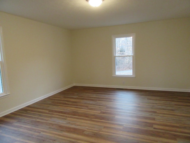 unfurnished room with dark hardwood / wood-style flooring