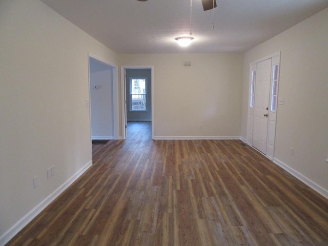 empty room featuring dark wood-type flooring and ceiling fan