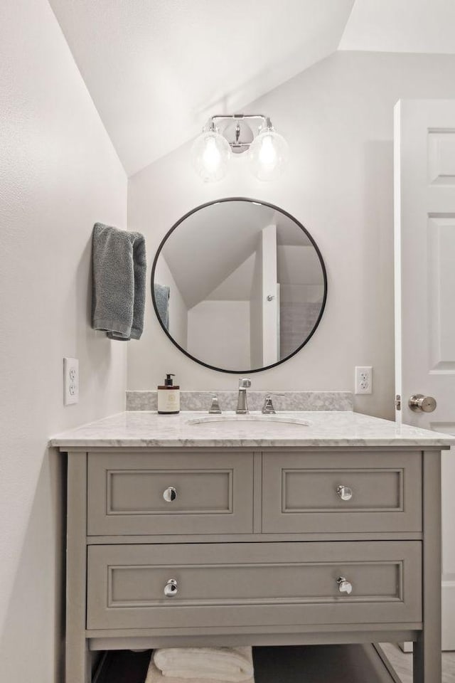 bathroom with lofted ceiling and vanity