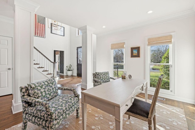 interior space featuring decorative columns, crown molding, and hardwood / wood-style flooring