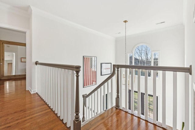 stairway with hardwood / wood-style floors, crown molding, and a wealth of natural light