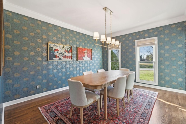 dining room with dark wood-type flooring, ornamental molding, and a notable chandelier