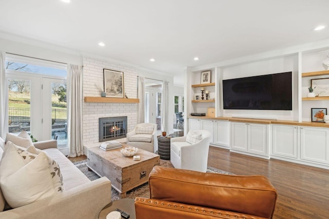 living room featuring crown molding, wood-type flooring, and a fireplace