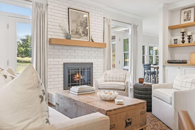 living room with ornamental molding and a brick fireplace