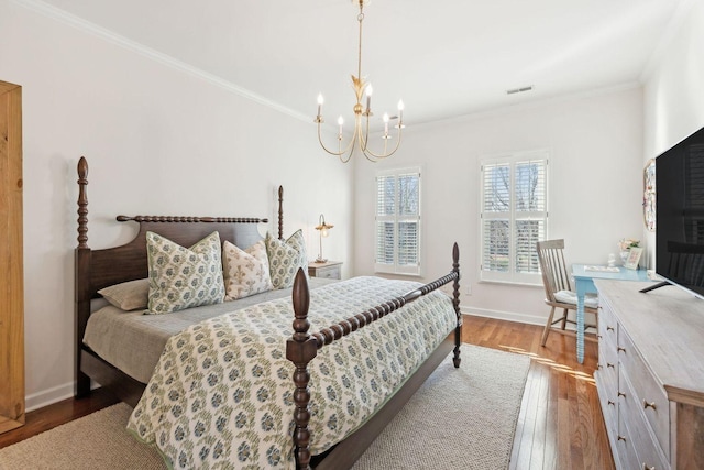 bedroom with hardwood / wood-style flooring, ornamental molding, and a chandelier