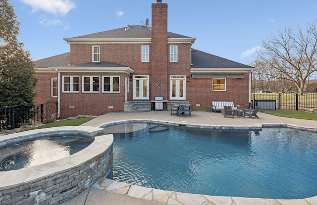 view of swimming pool with french doors, an in ground hot tub, and a patio