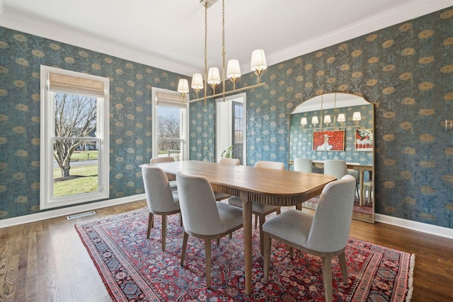 dining area with ornamental molding, dark hardwood / wood-style flooring, and a notable chandelier