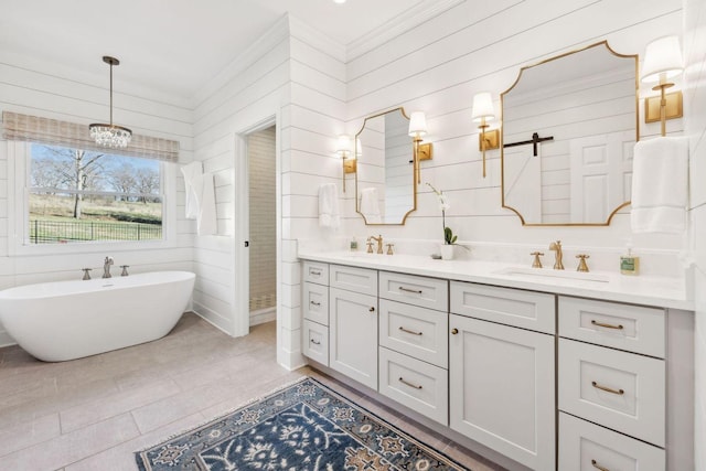 bathroom with vanity, a bath, and wood walls