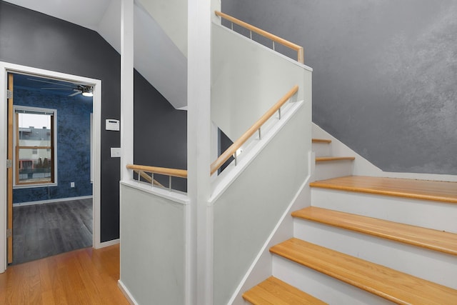 stairway featuring wood-type flooring, vaulted ceiling, and ceiling fan