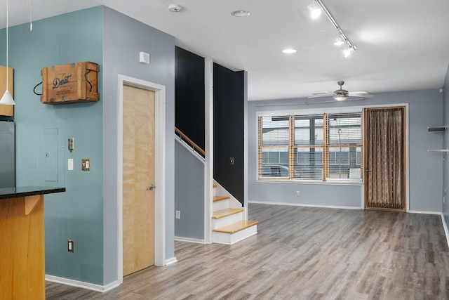 unfurnished living room with hardwood / wood-style floors, track lighting, and ceiling fan