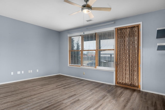 empty room with dark hardwood / wood-style floors and ceiling fan