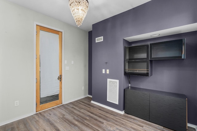 interior space featuring wood-type flooring and an inviting chandelier