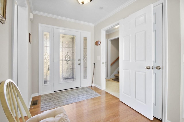 entrance foyer featuring ornamental molding and light hardwood / wood-style floors