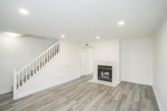 unfurnished living room featuring a textured ceiling, a fireplace, and light hardwood / wood-style floors