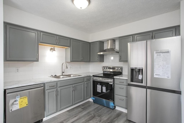 kitchen featuring backsplash, appliances with stainless steel finishes, sink, and wall chimney range hood