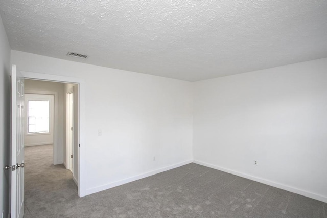 carpeted spare room with a textured ceiling