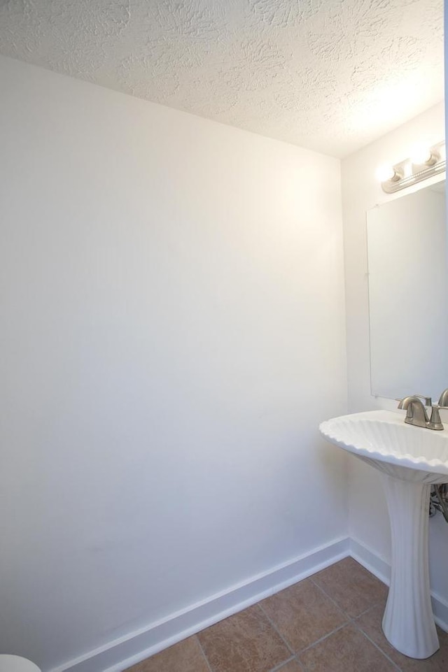 bathroom featuring tile patterned flooring, sink, and a textured ceiling