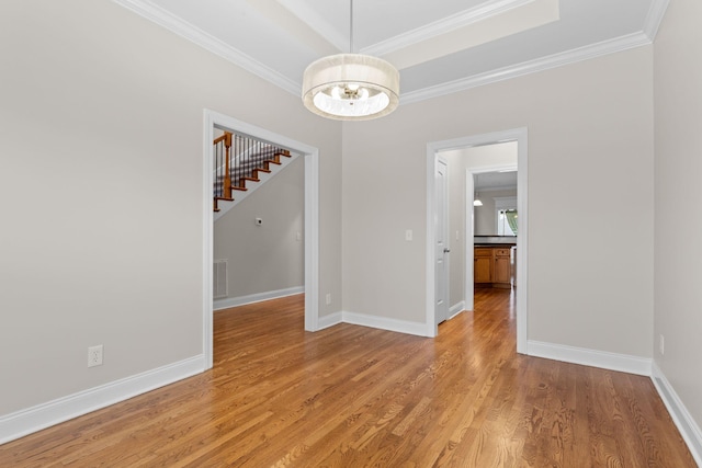 spare room featuring ornamental molding, light hardwood / wood-style flooring, and a notable chandelier