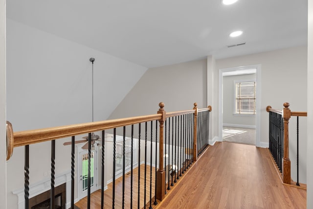 corridor featuring hardwood / wood-style floors and vaulted ceiling