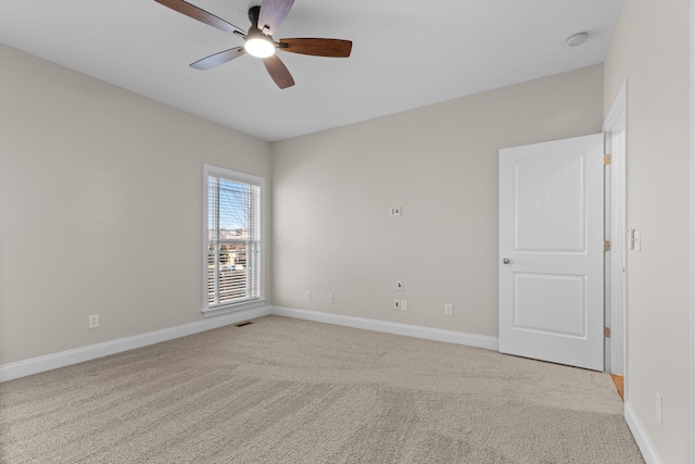 spare room featuring light carpet and ceiling fan