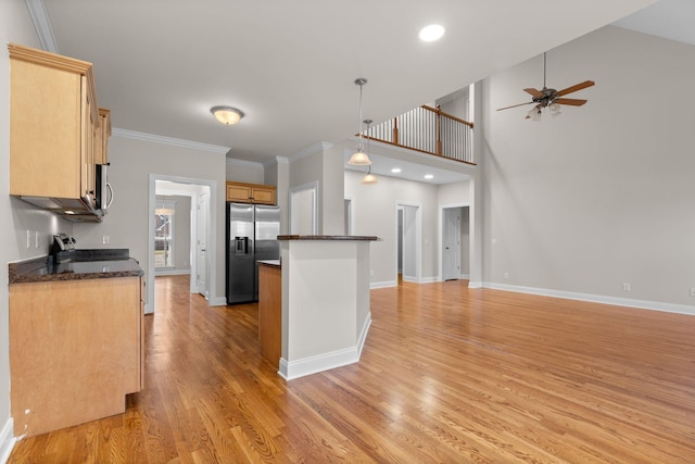 kitchen featuring pendant lighting, stainless steel appliances, crown molding, and light hardwood / wood-style floors