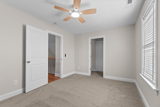 unfurnished bedroom with light colored carpet and ceiling fan