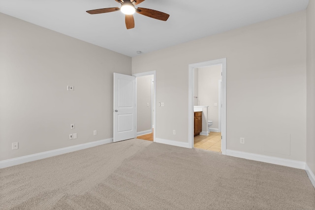 unfurnished bedroom with ceiling fan, light colored carpet, and ensuite bath