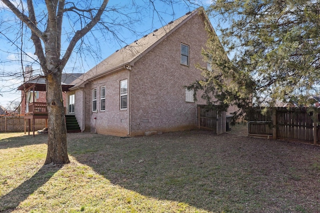 view of home's exterior with a wooden deck and a lawn