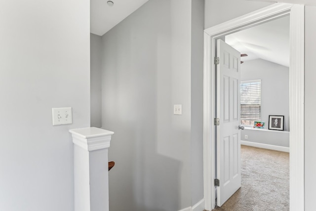 hall with vaulted ceiling and carpet flooring