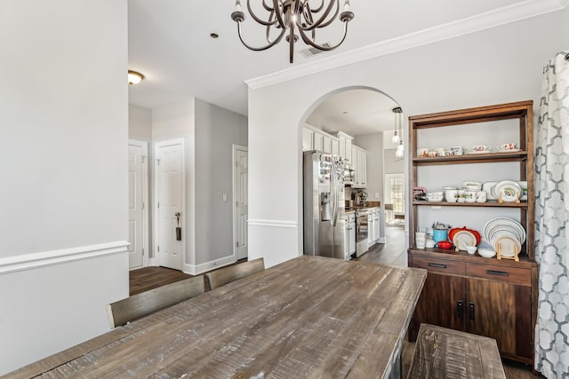 dining room featuring crown molding, dark hardwood / wood-style floors, and an inviting chandelier