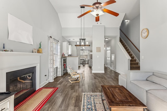 living room with ceiling fan, dark wood-type flooring, and high vaulted ceiling