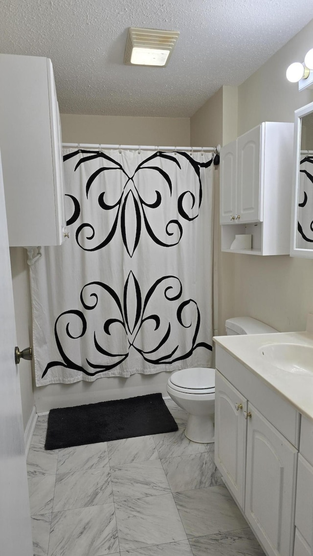 full bathroom with vanity, toilet, a textured ceiling, and shower / bath combo