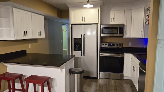 kitchen featuring white cabinetry, appliances with stainless steel finishes, and kitchen peninsula