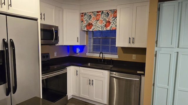 kitchen featuring appliances with stainless steel finishes, sink, and white cabinets