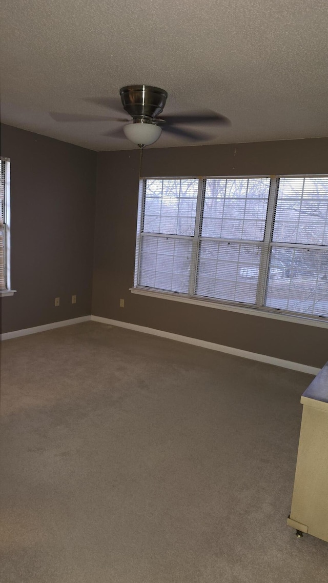 carpeted empty room with a textured ceiling and ceiling fan