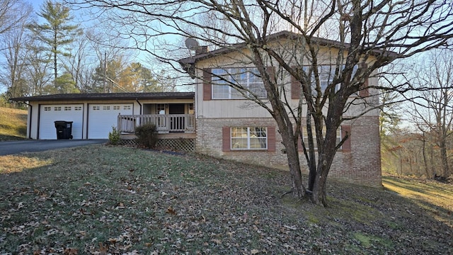 view of front of property with a garage, a deck, and a front lawn