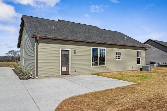 back of property with a patio, a yard, and central AC