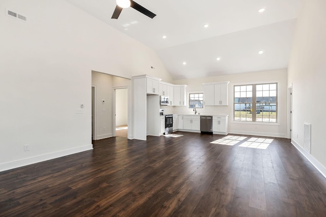 unfurnished living room with sink, dark wood-type flooring, high vaulted ceiling, and ceiling fan