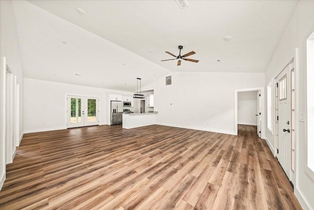 unfurnished living room featuring french doors, ceiling fan, lofted ceiling, and light hardwood / wood-style flooring