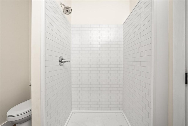 bathroom with toilet and a tile shower