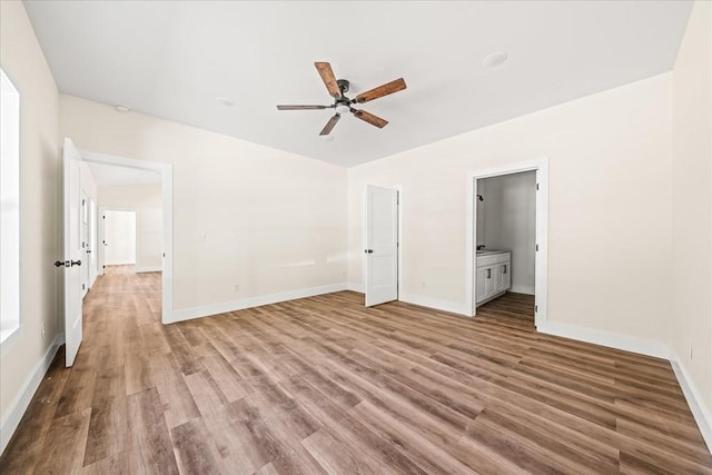 unfurnished bedroom with ceiling fan, ensuite bathroom, and hardwood / wood-style floors